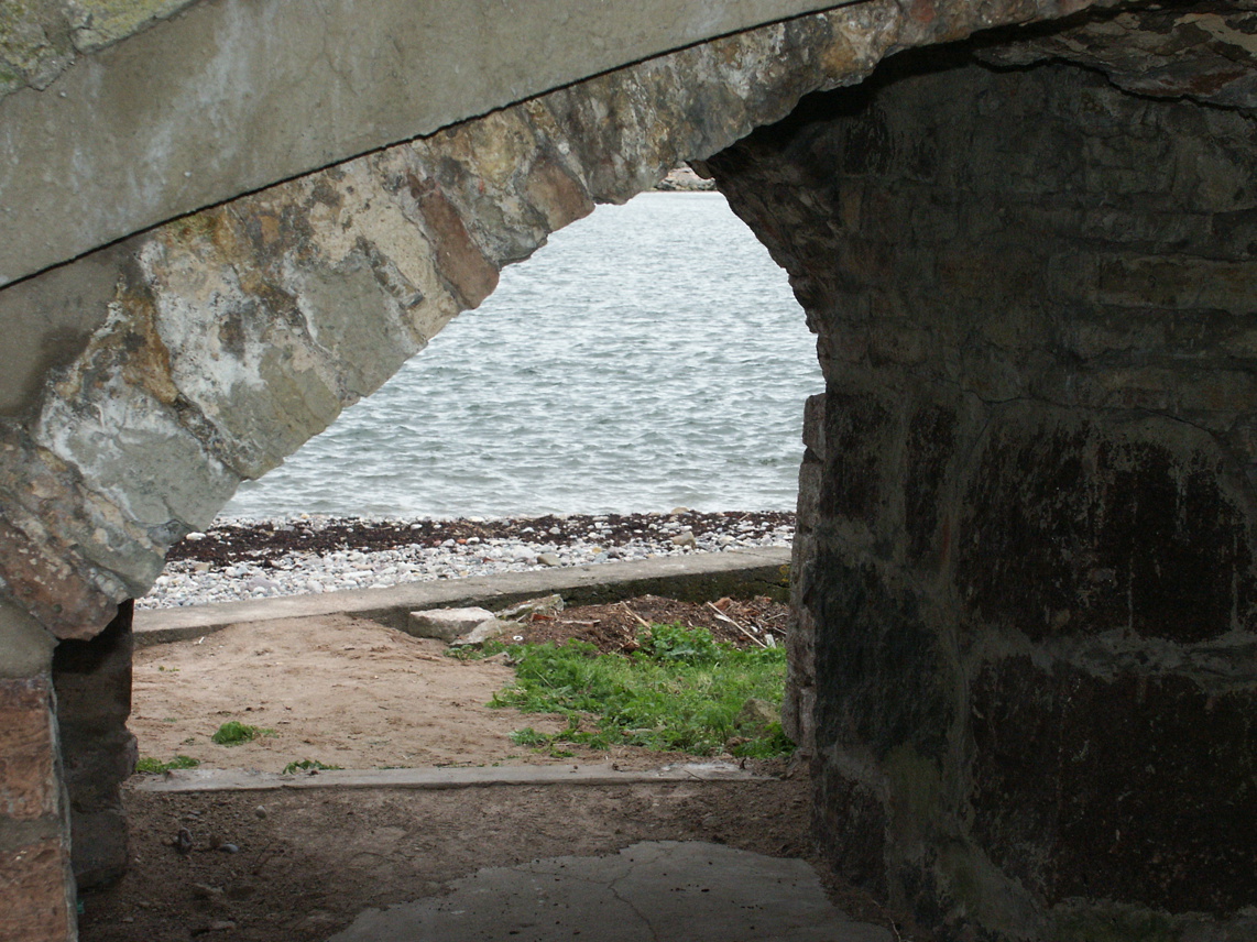 Grimskärs skans. Genom ett valv i befästningen syns stranden och vattnet.