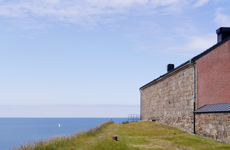 Varbergs fästning. Utsikt över havet. Till höger i bild syns en av slottsbyggnaderna med rödputsad gavel.