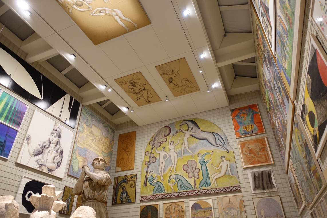 Utställnings-hall i Skissernas museum. Rummet är fullt av skulpturer och målningar, även i taket.