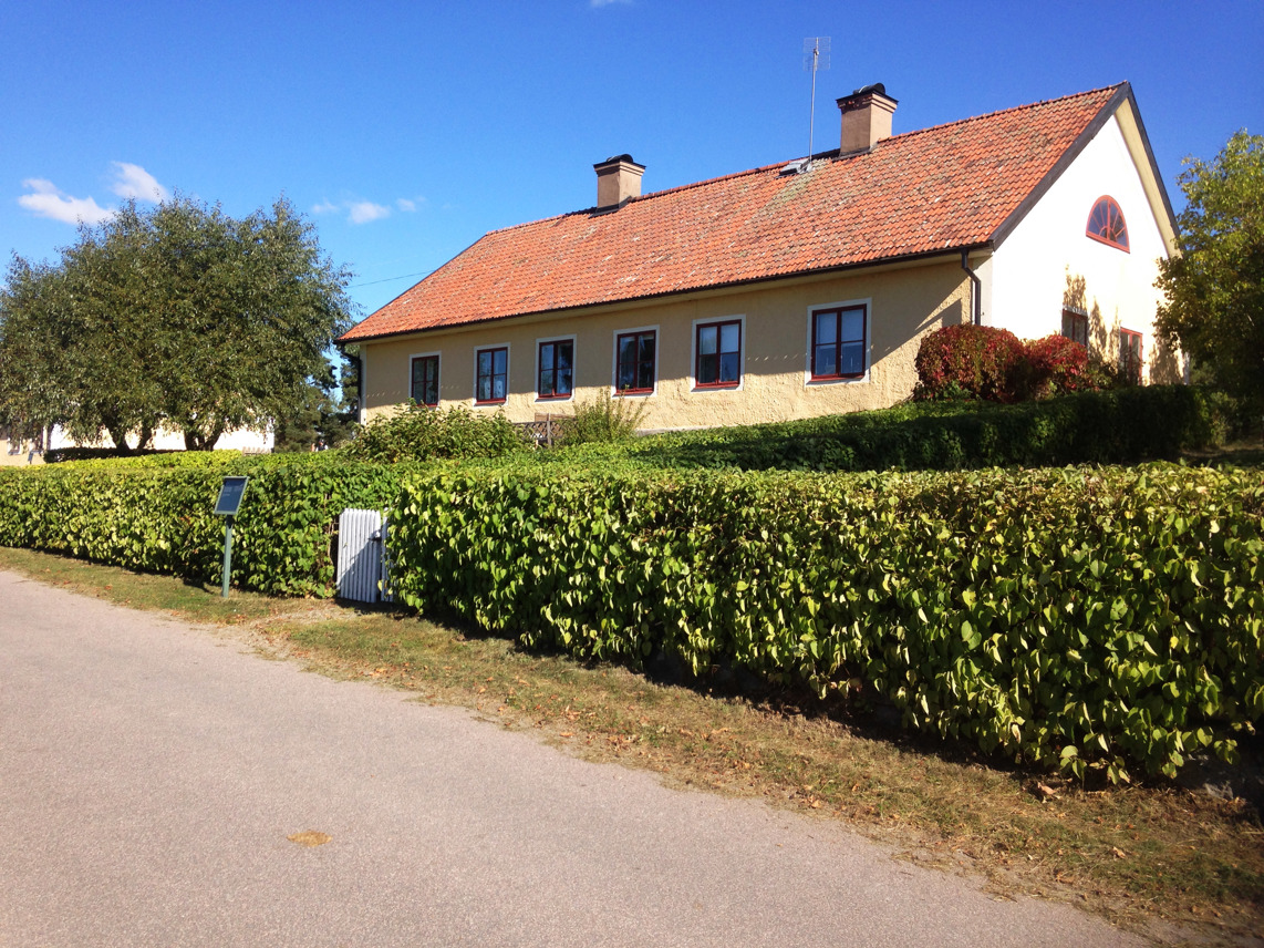 Exteriör, bostadshus vid Snobbrännan. Gulputsad byggnad med tegeltak. Sommar.