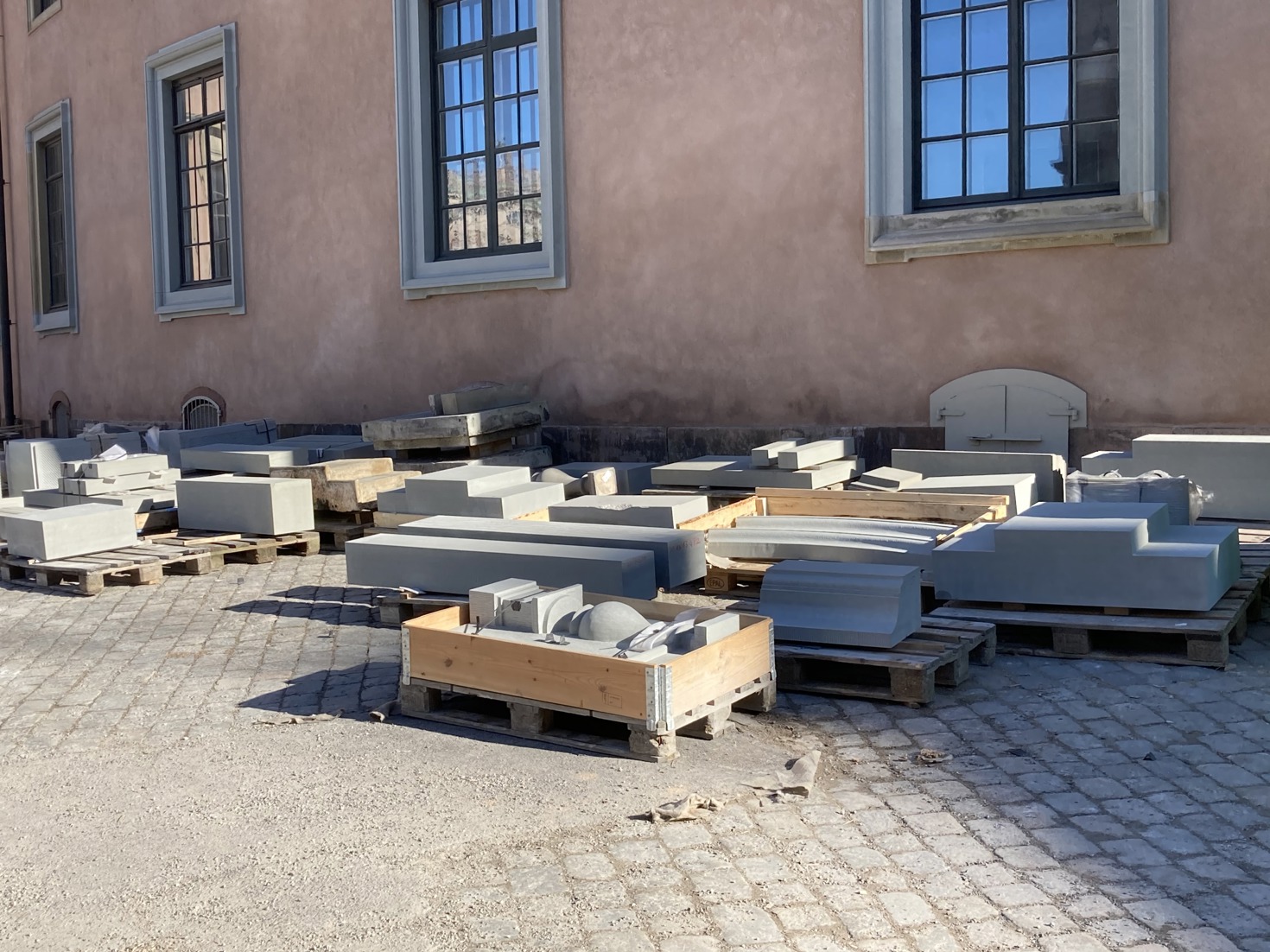Flertal pallkragar fulla med stora block av sten.
