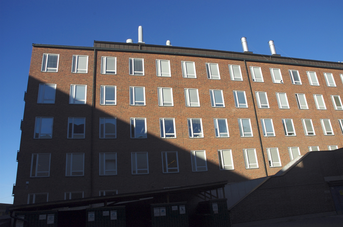 Före detta Kemiska övningslaboratoriet. En hög, långsträckt tegelbyggnad i senfunkis-stil.